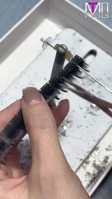 Manually segmenting and trimming our lash clusters to guarantee flawless, natura