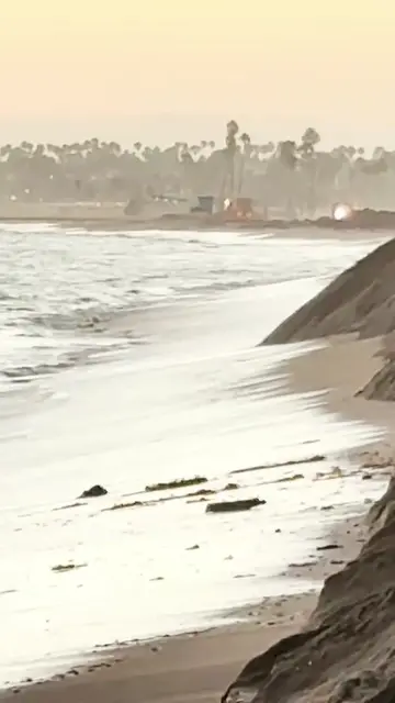 Crews in Long Beach are using heavy equipment to build up protective sand berms 
