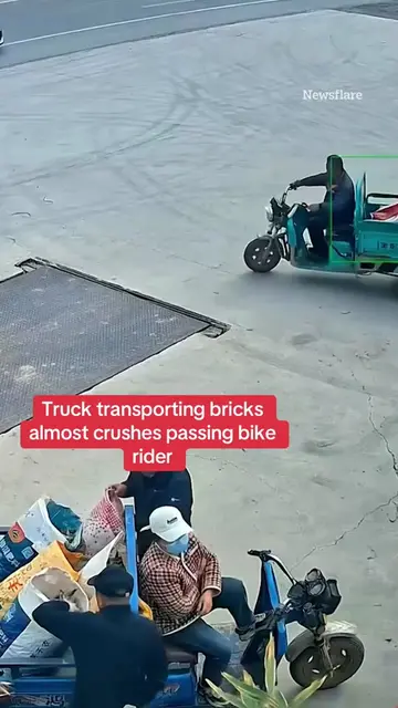This is the shocking moment a truck transporting bricks almost crushes a passing