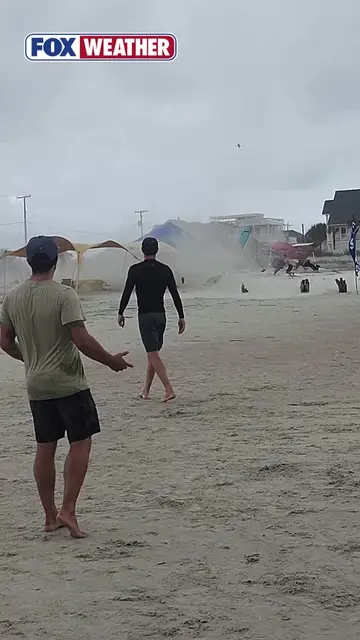 BEACH TWISTER 🌪️: Beachgoers were sent running for cover after a waterspout sud