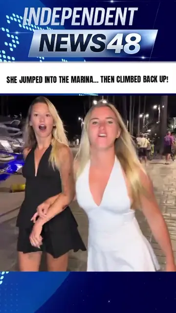 This woman in a white dress is walking along the marina at night with her friend