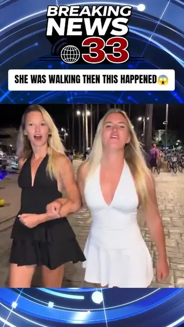 This woman in a white dress is walking along the marina at night with her friend