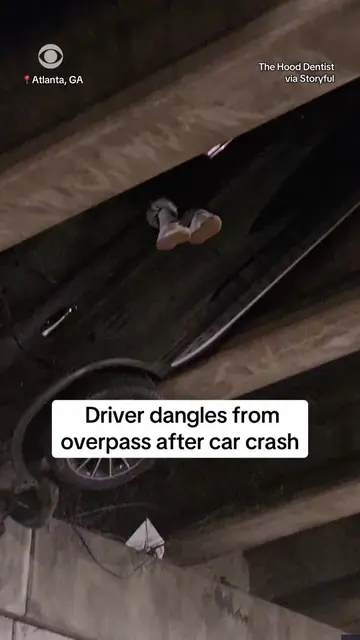 A person was seen dangling from an overpass in downtown Atlanta after a car cras