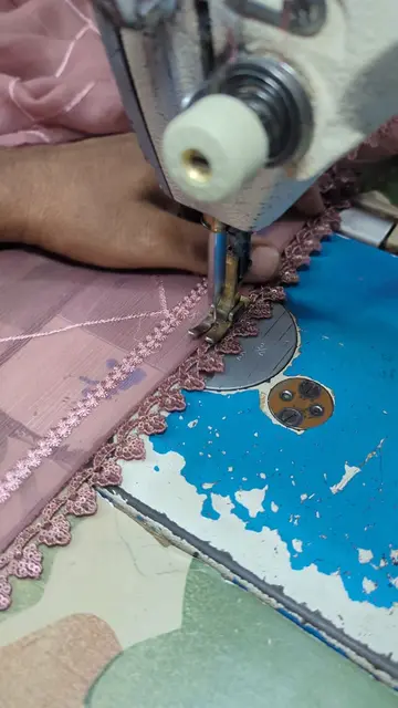 Stitching lace on the dupatta with complete focus, while Nasir Madni sahab’s hil