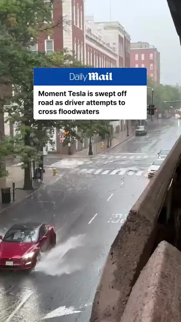 A Tesla was swept away after its driver attempted to cross a heavily flooded str